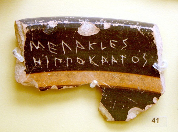 broken shard of pottery with names in greek inscribed into them.
