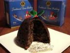 dark lions christmas pudding on a white plate with blue pudding boxes behind it